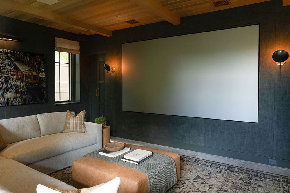 Media room with dark walls and beamed ceiling