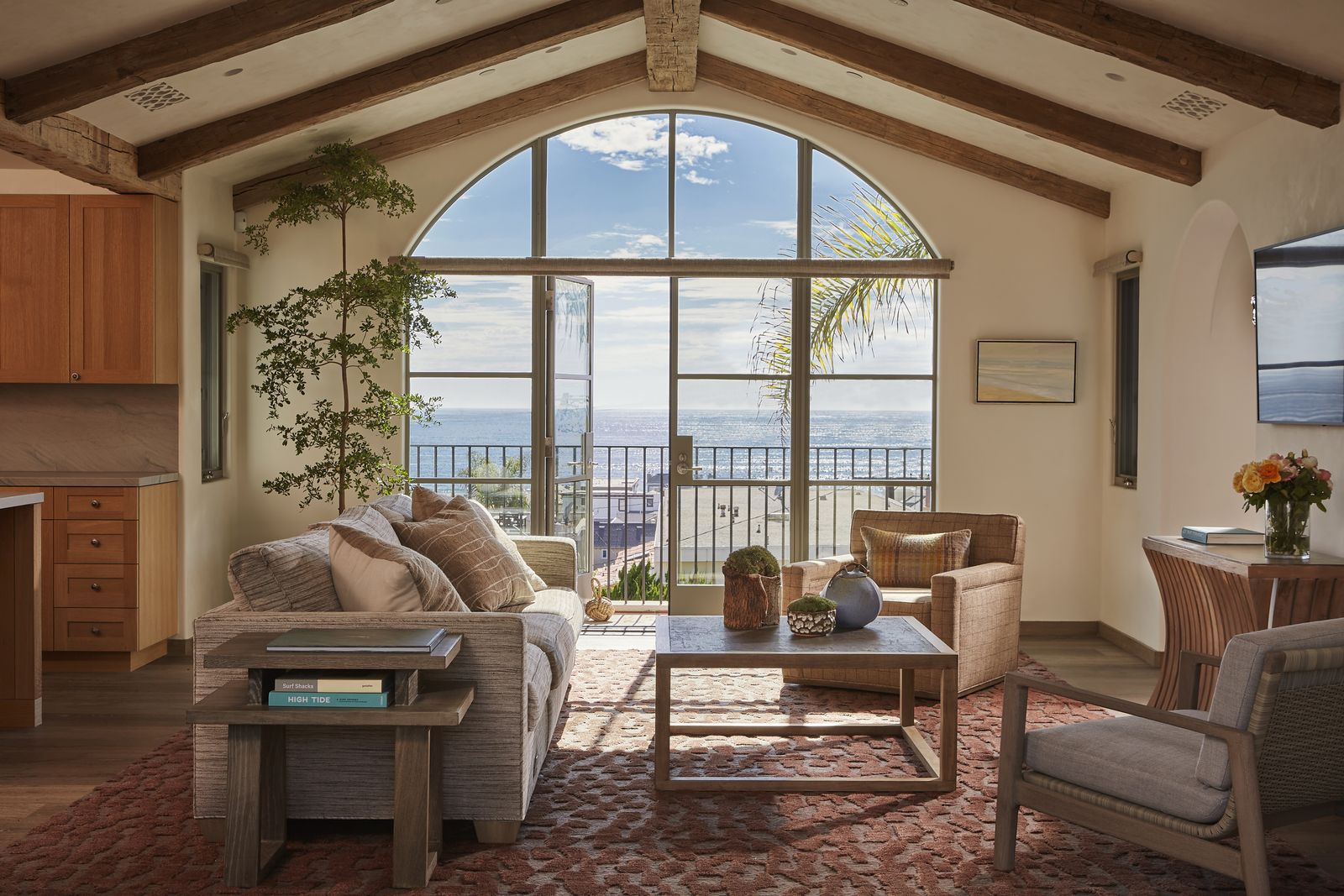 Vaulted living room with arched window and beams